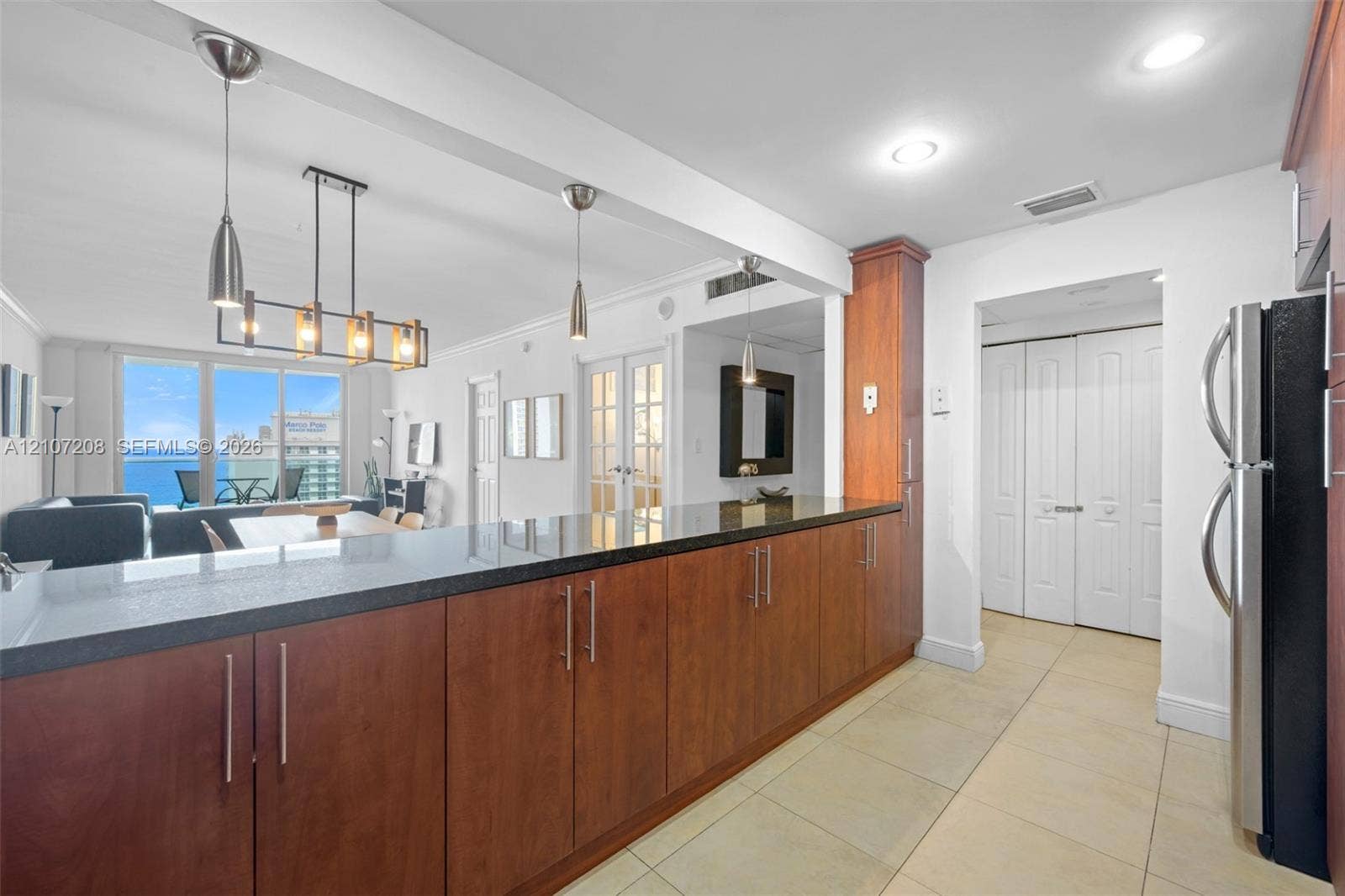19370 Collins Avenue, #1405, Sunny Isles Beach, Sunny Isles Beach, FL 33160 Kitchen featuring wood cabinetry, dark stone-finish countertops, recessed lighting, tile flooring, and a multi-light pendant fixture