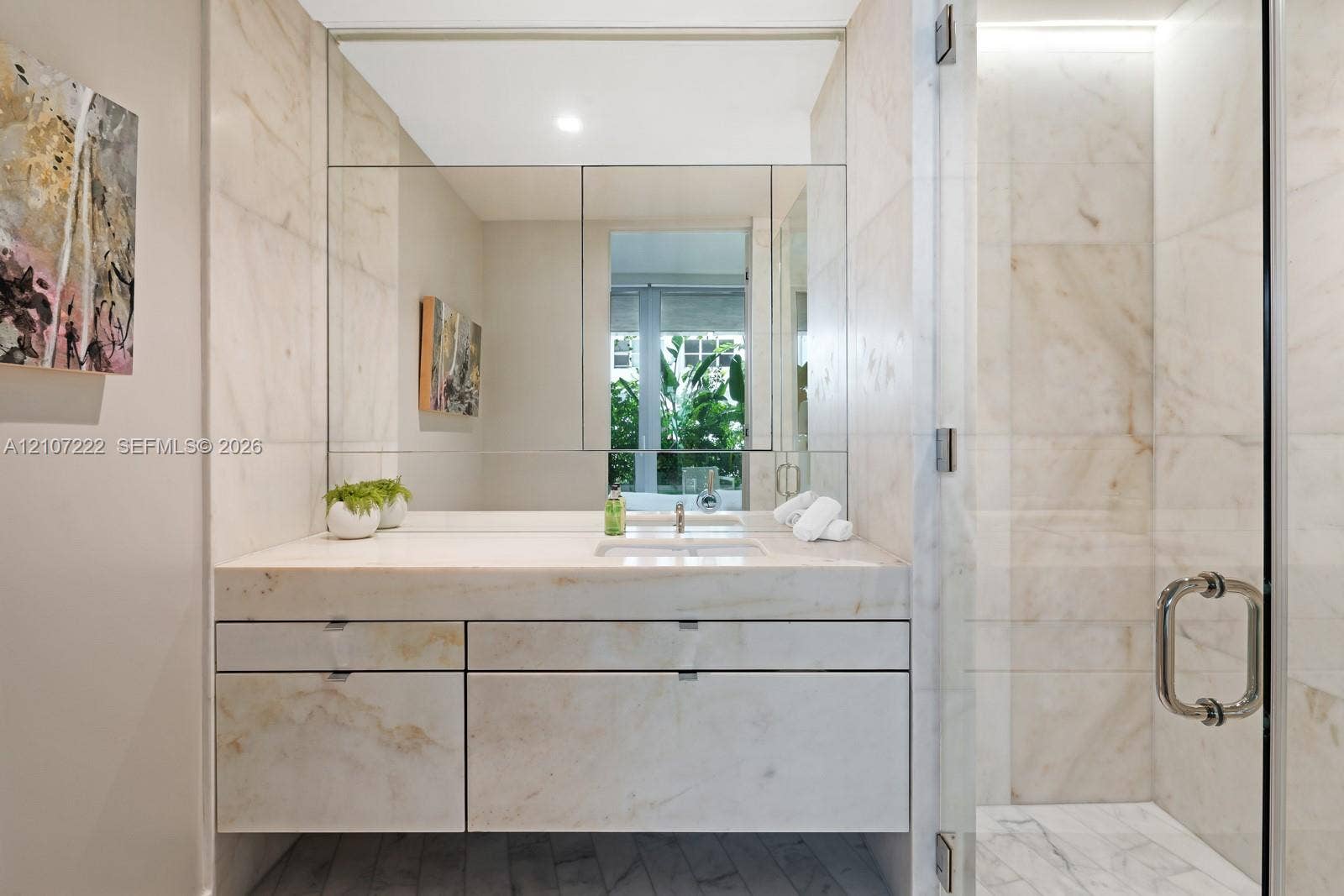 1300 Monad Terrace, #2F, Miami Beach, FL 33139 Floating vanity with stone-surfaced countertop, large-format tiled shower enclosure, glass entry door, and wall-to-wall mirror