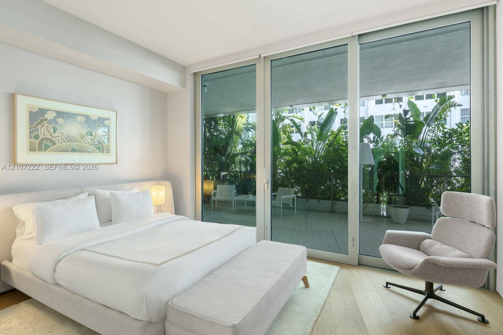 1300 Monad Terrace, #2F, Miami Beach, FL 33139 Floor-to-ceiling sliding glass doors, neutral wood-finish flooring, and expansive private balcony with perimeter railing