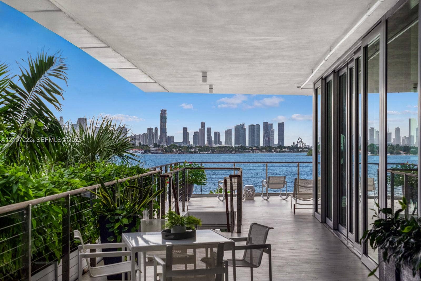 1300 Monad Terrace, #2F, Miami Beach, FL 33139 Covered outdoor terrace featuring oversized tile flooring, cable railing, floor-to-ceiling glass panel doors, and water and skyline scenery