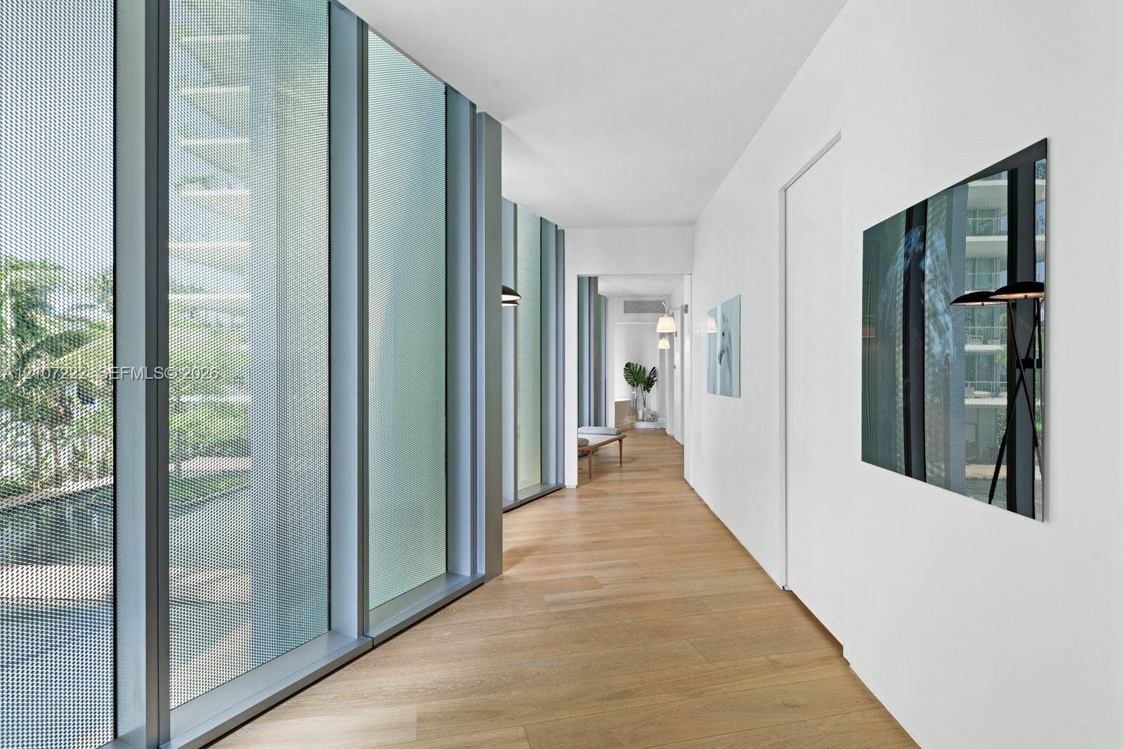 1300 Monad Terrace, #2F, Miami Beach, FL 33139 Floor-to-ceiling metal-framed windows, wood-finish flooring, and crisp white walls