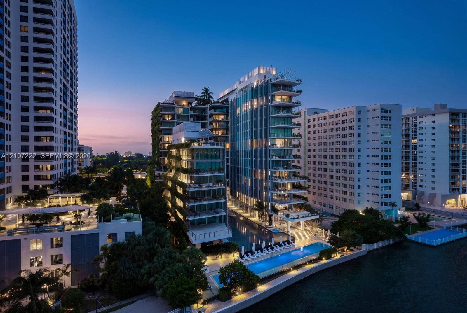 1300 Monad Terrace, #2F, Miami Beach, FL 33139 High-rise residential exterior featuring expansive glass balconies, vertical garden facades, waterfront lap pool, and integrated hardscaping