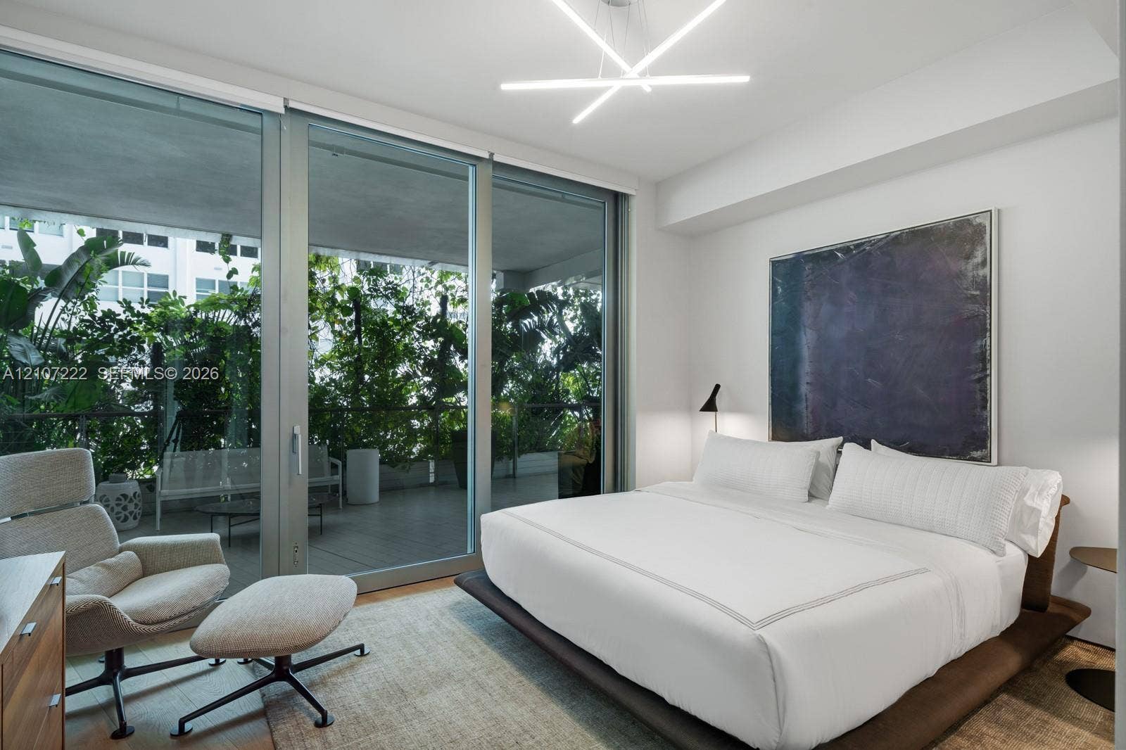 1300 Monad Terrace, #2F, Miami Beach, FL 33139 Floor-to-ceiling sliding glass panels, private balcony, contemporary geometric chandelier, and neutral wall finish