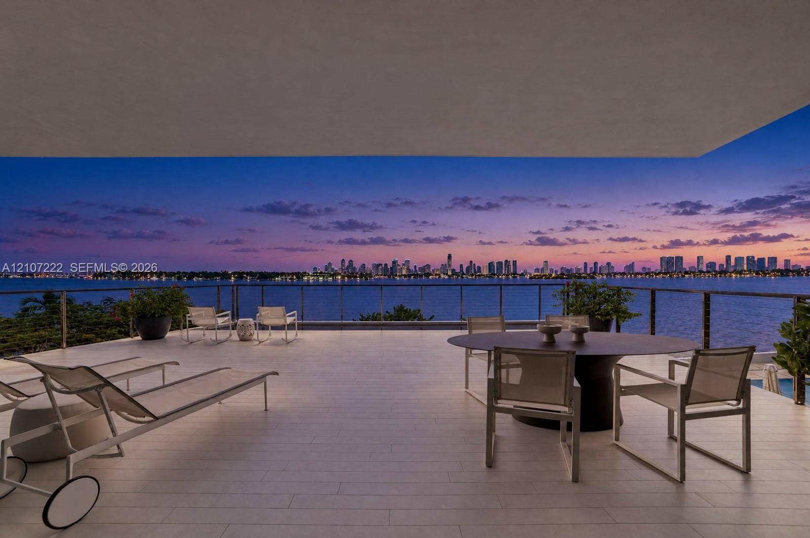 1300 Monad Terrace, #2F, Miami Beach, FL 33139 Covered terrace featuring light-toned tile flooring, a glass-panel railing, and panoramic water and city skyline backdrop