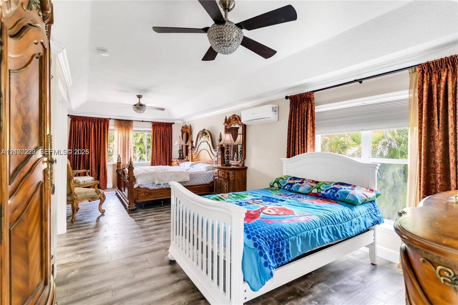 5280 NW 95th Avenue, Coral Springs, Coral Springs, FL 33076 Tray ceiling with recessed lighting, wood-finish flooring, dual ceiling fans with crystal accents, and wall-mounted ductless climate control unit