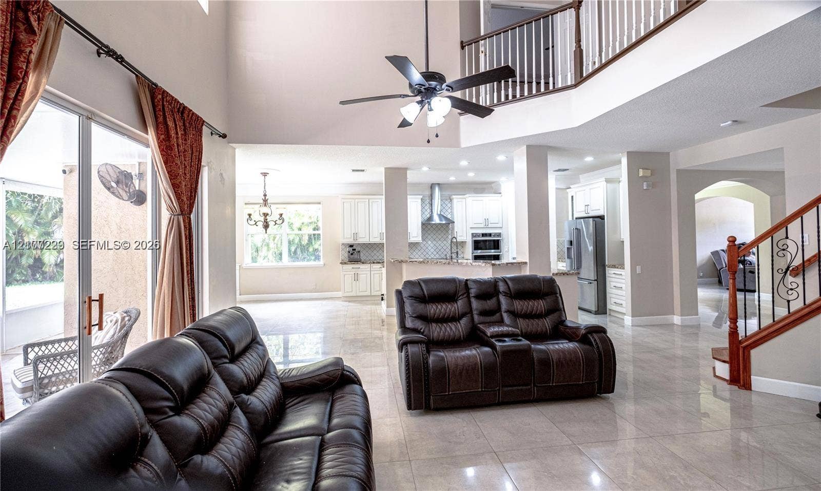 5280 NW 95th Avenue, Coral Springs, Coral Springs, FL 33076 Two-story height ceiling with overlook, tile flooring throughout, staircase with decorative metal balusters, and recessed ceiling lighting