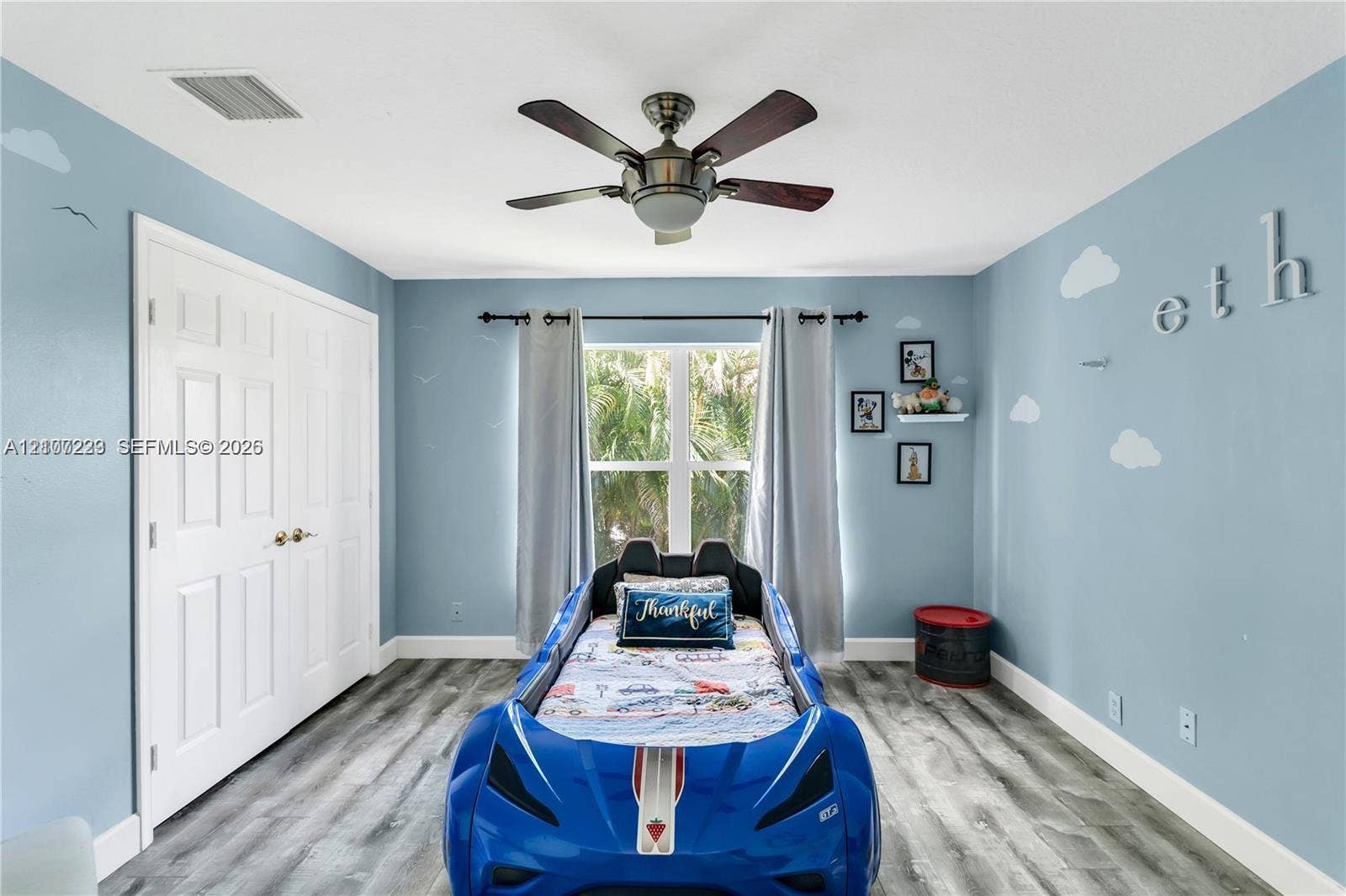 5280 NW 95th Avenue, Coral Springs, Coral Springs, FL 33076 Bedroom featuring wood-finish flooring, a multi-blade ceiling fan with integrated lighting, and a double-door closet