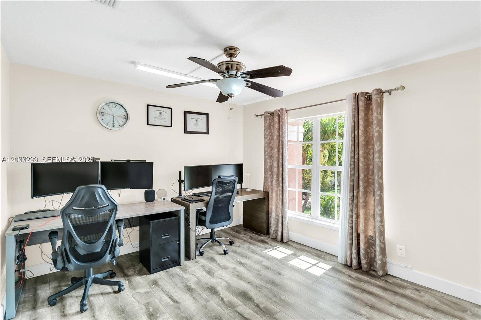 5280 NW 95th Avenue, Coral Springs, Coral Springs, FL 33076 Room featuring wood-finish flooring, a multi-pane window with a curtain rod, and a ceiling fan with integrated lighting