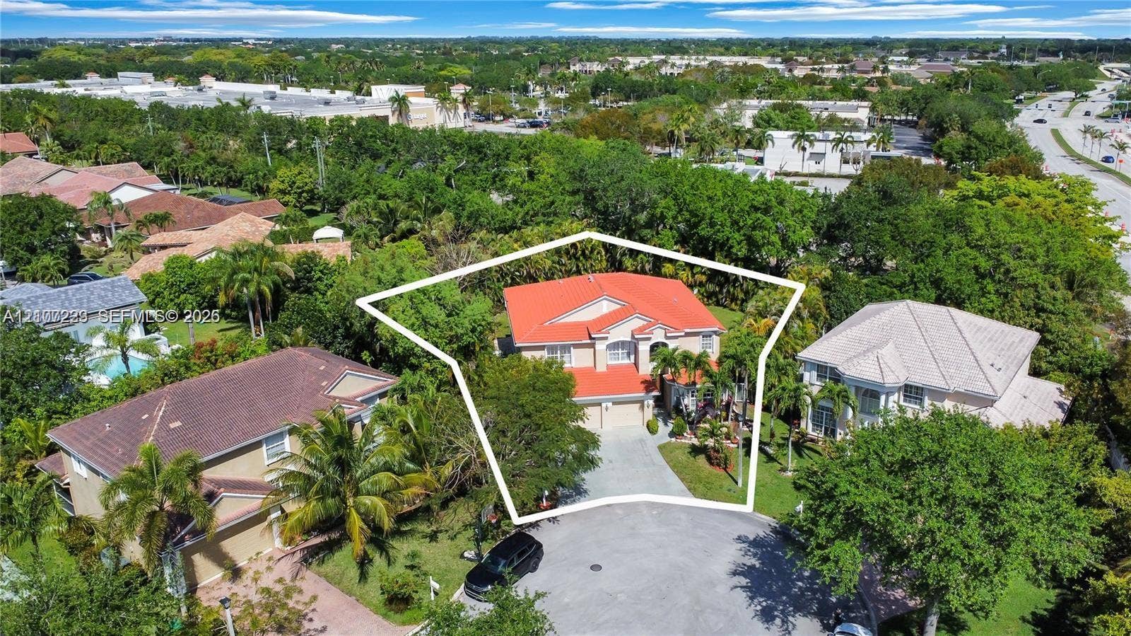 5280 NW 95th Avenue, Coral Springs, Coral Springs, FL 33076 Two-story residence featuring a terracotta-tiled roof, light-toned exterior finish, multi-car garage, concrete driveway, and established perimeter vegetation