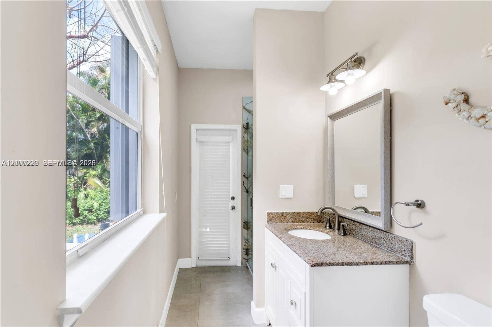 5280 NW 95th Avenue, Coral Springs, Coral Springs, FL 33076 Bathroom featuring a white vanity with a stone countertop, an oval undermount sink, a framed mirror, and tile flooring