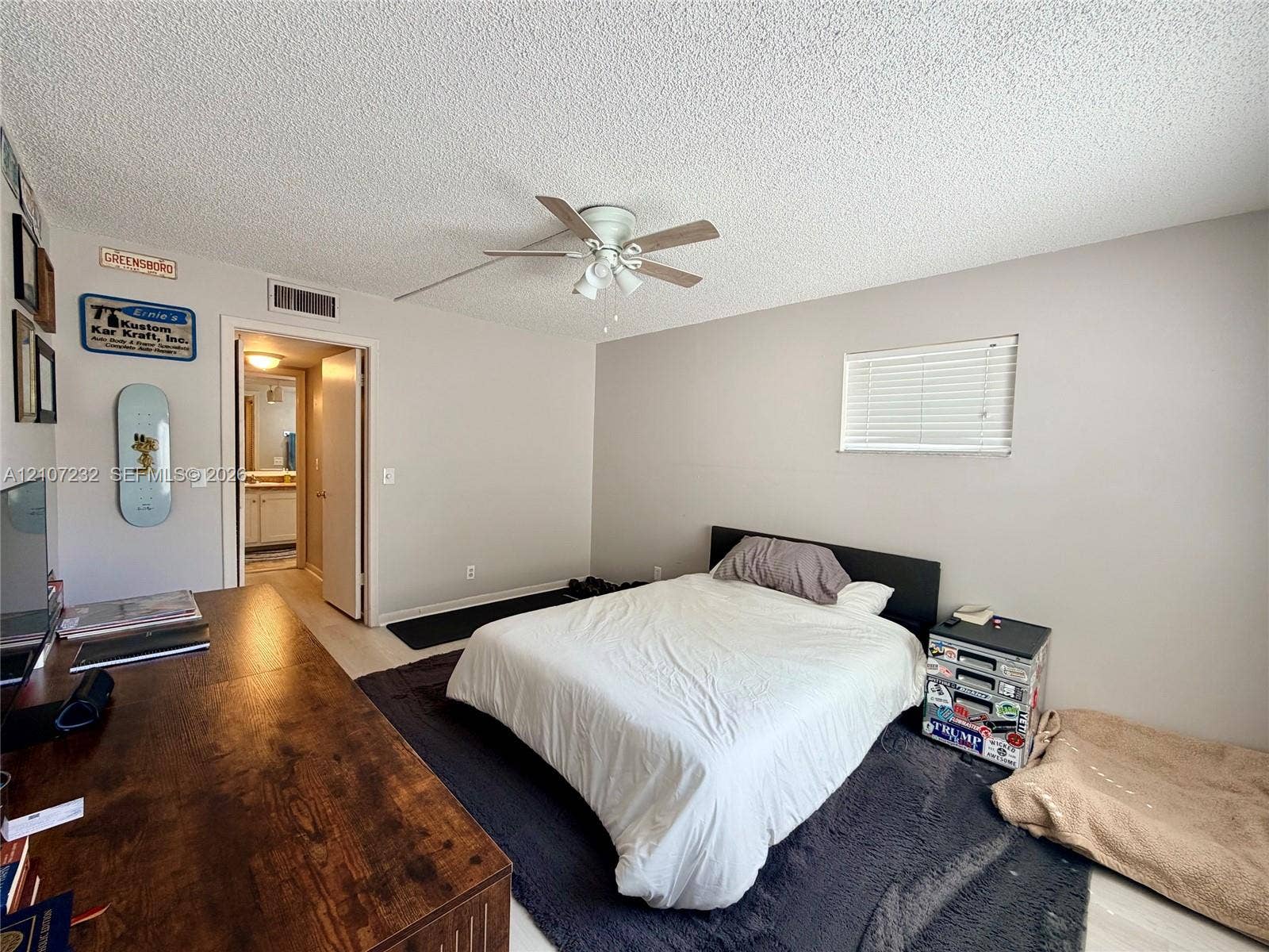 Room featuring neutral-toned walls, a ceiling fan with integrated lighting, and a horizontal window with blinds