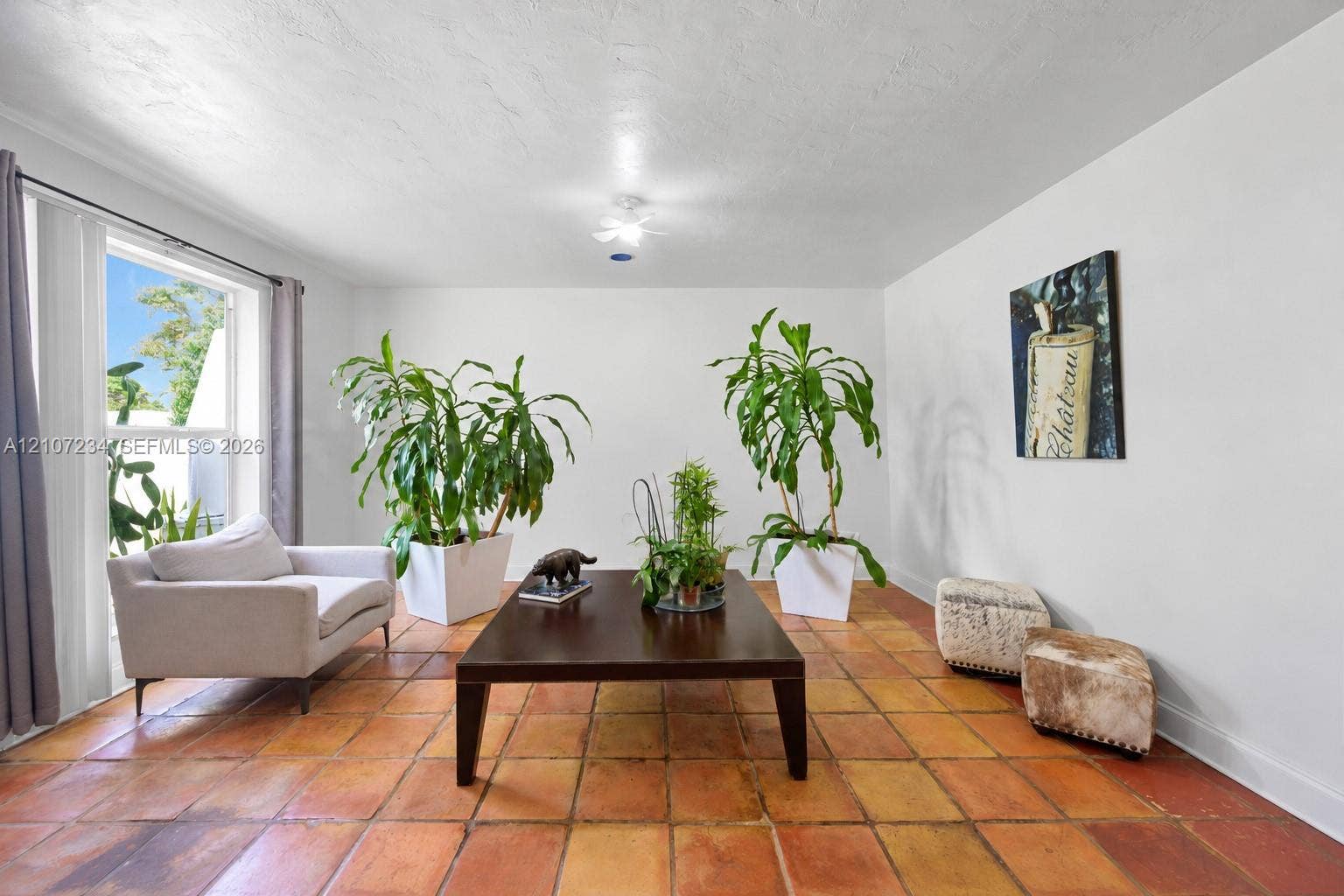 13507 NE 24th Court, North Miami, FL 33181 Interior space featuring large-format terra cotta tile flooring, expansive window with natural lighting, and ceiling-mounted light fixture