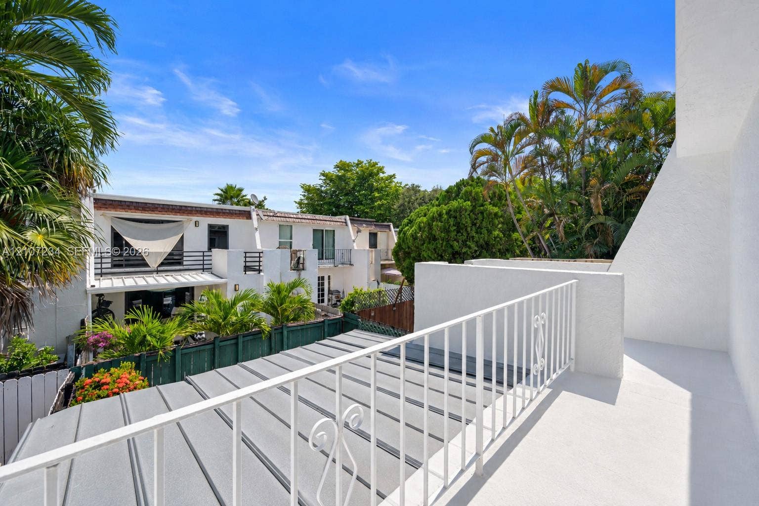 13507 NE 24th Court, North Miami, FL 33181 Elevated balcony featuring a white metal railing, solid flooring, and a metal-paneled roof covering
