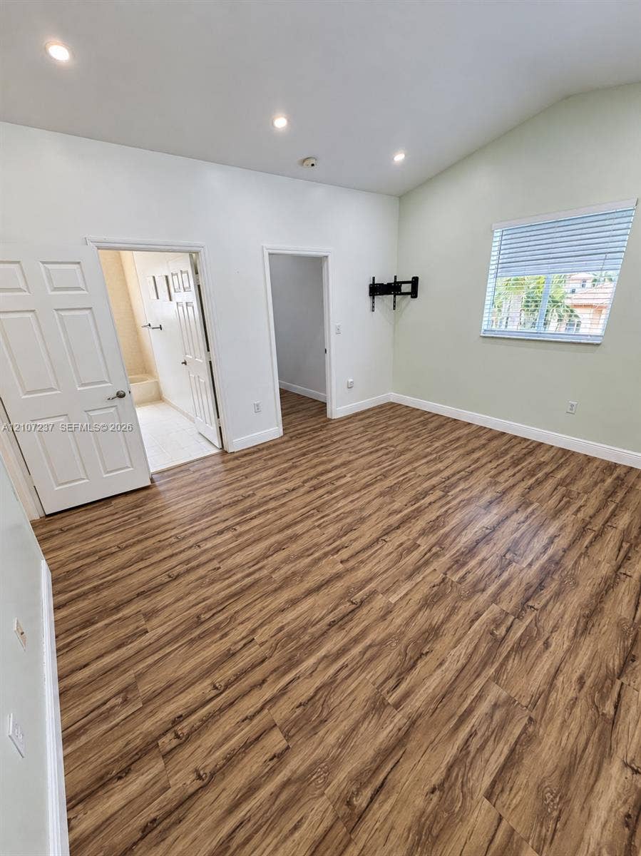 2529 NE 41st Terrace, Homestead, FL 33033 Room featuring wood-finish flooring, recessed lighting, vaulted ceilings, and a window with horizontal blinds