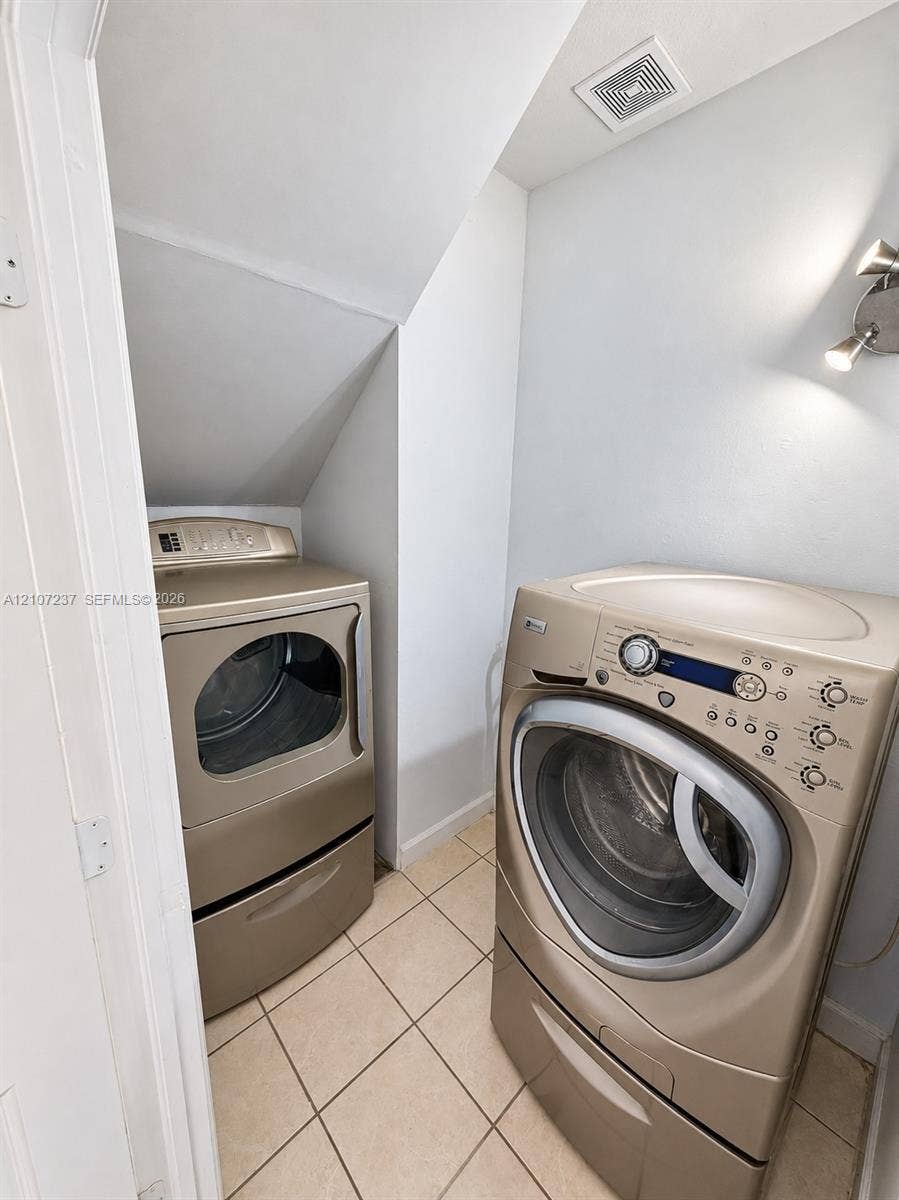 2529 NE 41st Terrace, Homestead, FL 33033 Laundry space featuring large-format ceramic tile flooring and wall-mounted metal task lighting