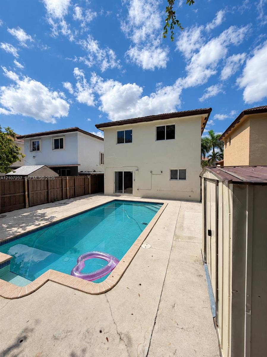 2529 NE 41st Terrace, Homestead, FL 33033 Rectangular swimming pool with tiled coping, expansive concrete pool deck, and perimeter wood privacy fencing