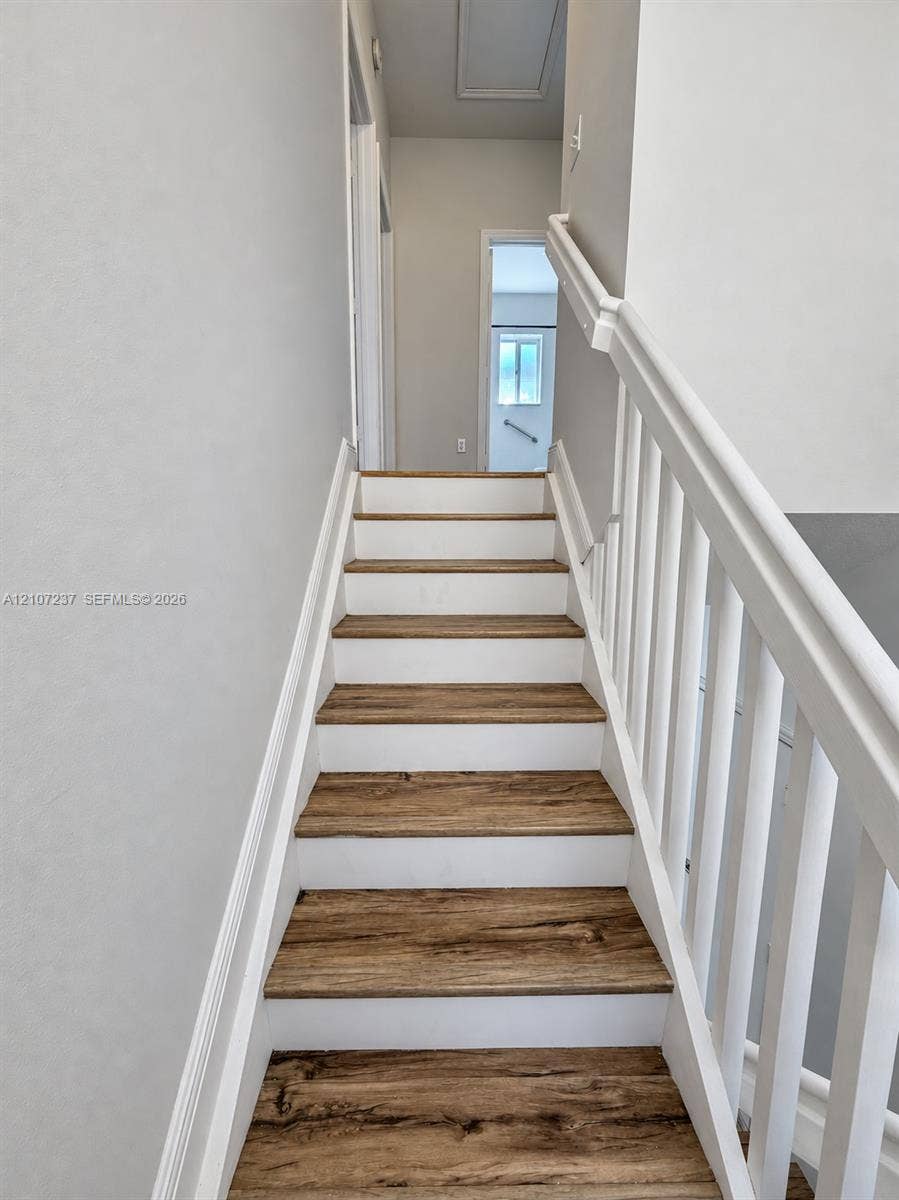 2529 NE 41st Terrace, Homestead, FL 33033 Staircase featuring wood-finish treads, white risers, and a white baluster railing