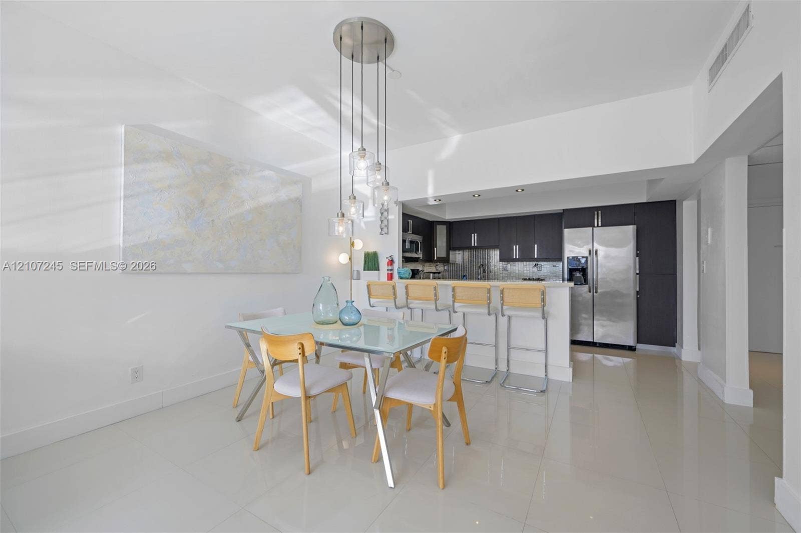 19370 Collins Avenue, #PH-14, Sunny Isles Beach, Sunny Isles Beach, FL 33160 Kitchen featuring dark cabinetry, stainless steel appliances, breakfast bar, and multi-light pendant fixture over tile flooring