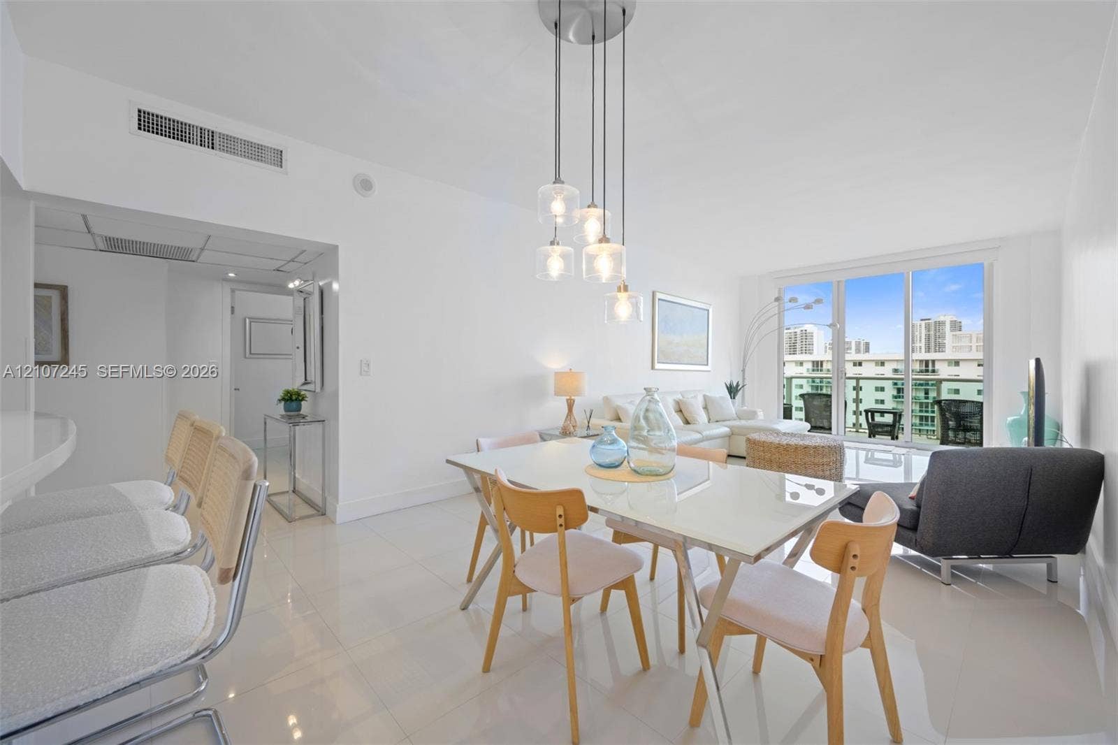 19370 Collins Avenue, #PH-14, Sunny Isles Beach, Sunny Isles Beach, FL 33160 Open-concept living space featuring high-gloss tile flooring, multi-pendant glass lighting, built-in recessed ceiling lighting, and floor-to-ceiling glass sliding doors