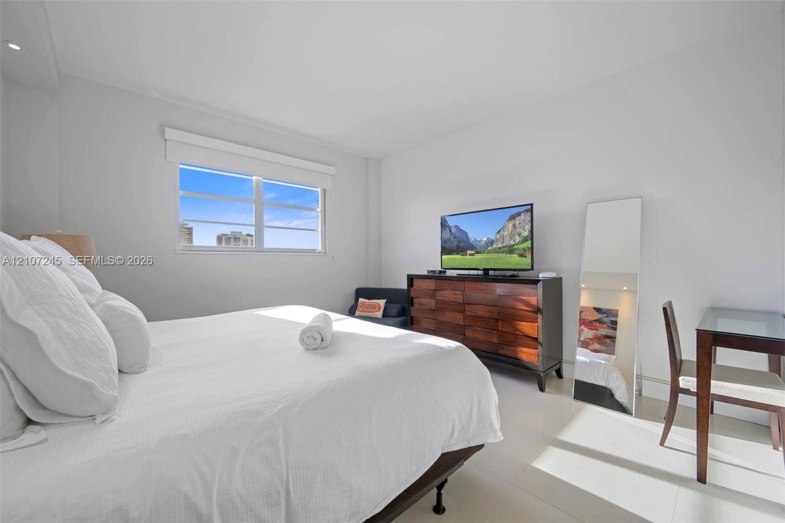19370 Collins Avenue, #PH-14, Sunny Isles Beach, Sunny Isles Beach, FL 33160 Neutral-toned bedroom featuring white-finish tile flooring, recessed ceiling lighting, and a window with a horizontal blind