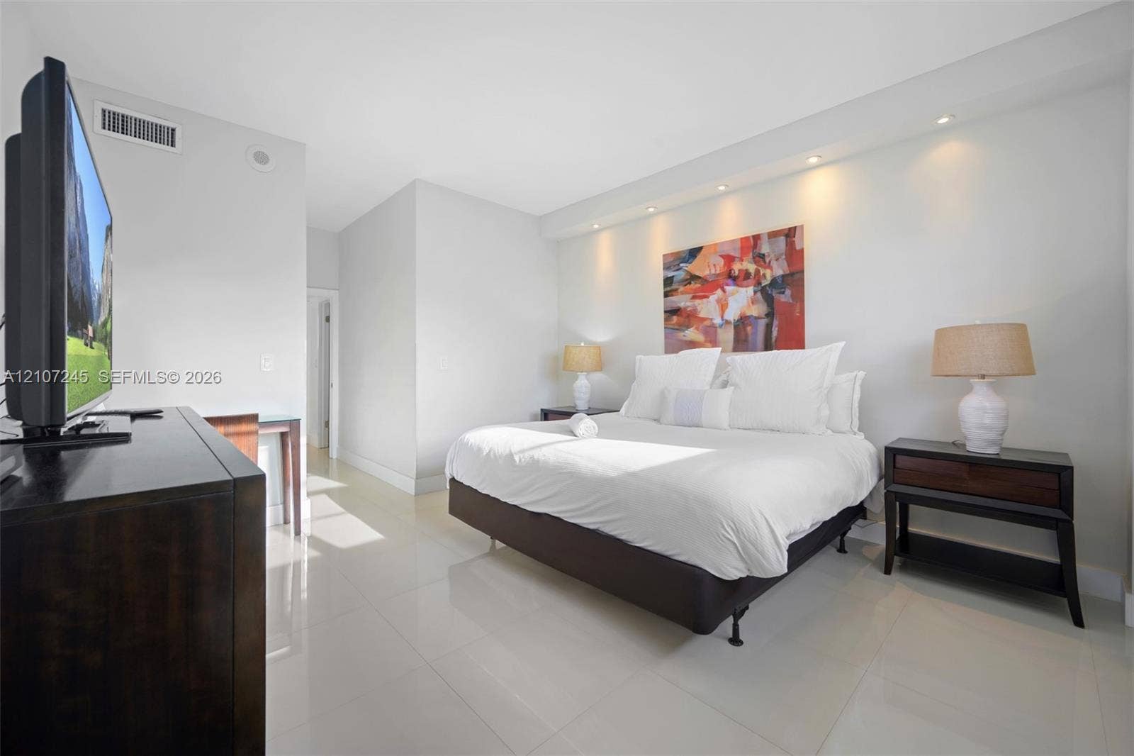 19370 Collins Avenue, #PH-14, Sunny Isles Beach, Sunny Isles Beach, FL 33160 Neutral-toned room featuring large-format tile flooring, recessed ceiling lighting, and a recessed architectural wall niche above the bed area