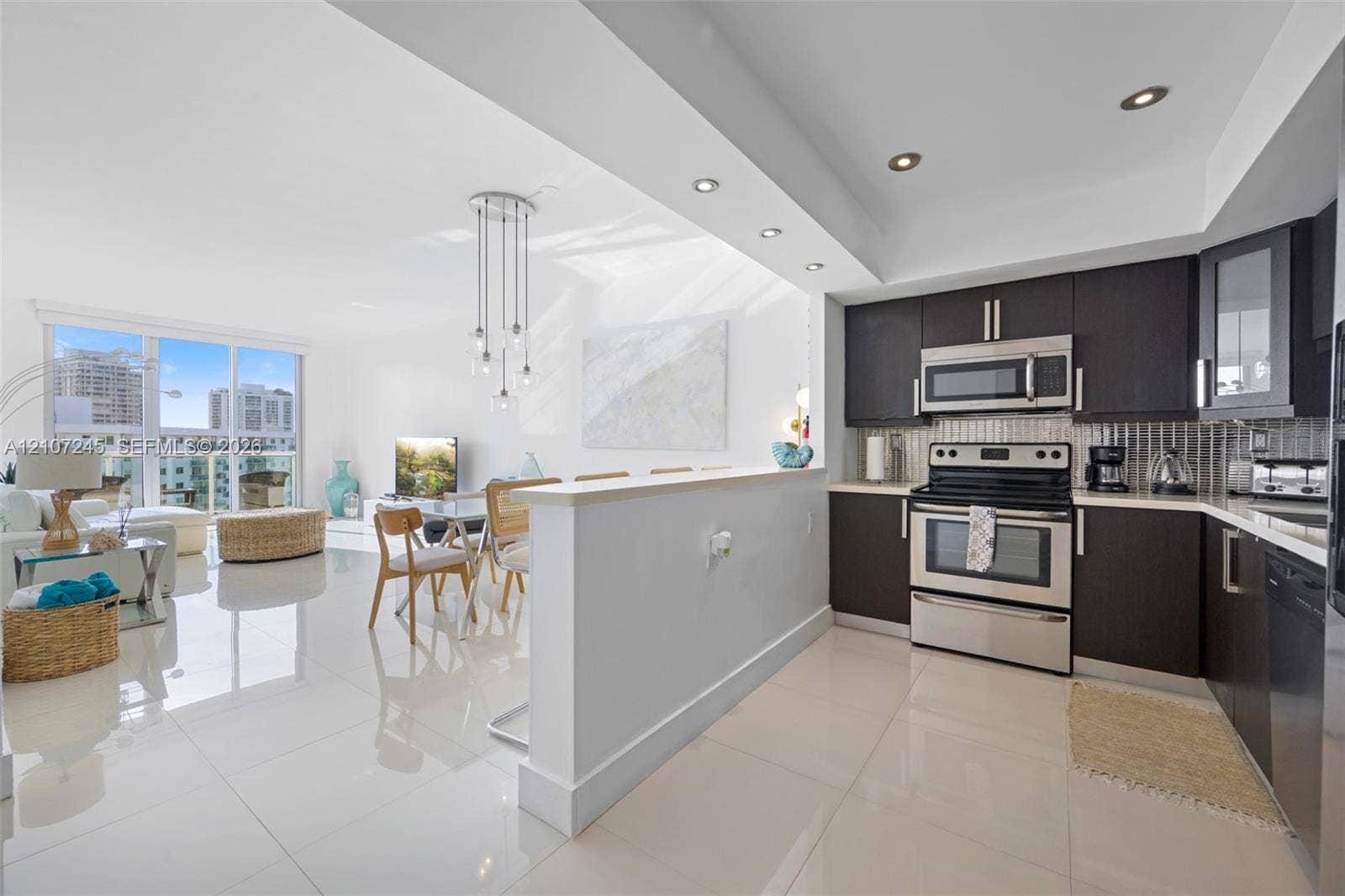 19370 Collins Avenue, #PH-14, Sunny Isles Beach, Sunny Isles Beach, FL 33160 Kitchen featuring dark cabinetry, stainless steel appliances, recessed lighting, and large-format tile flooring