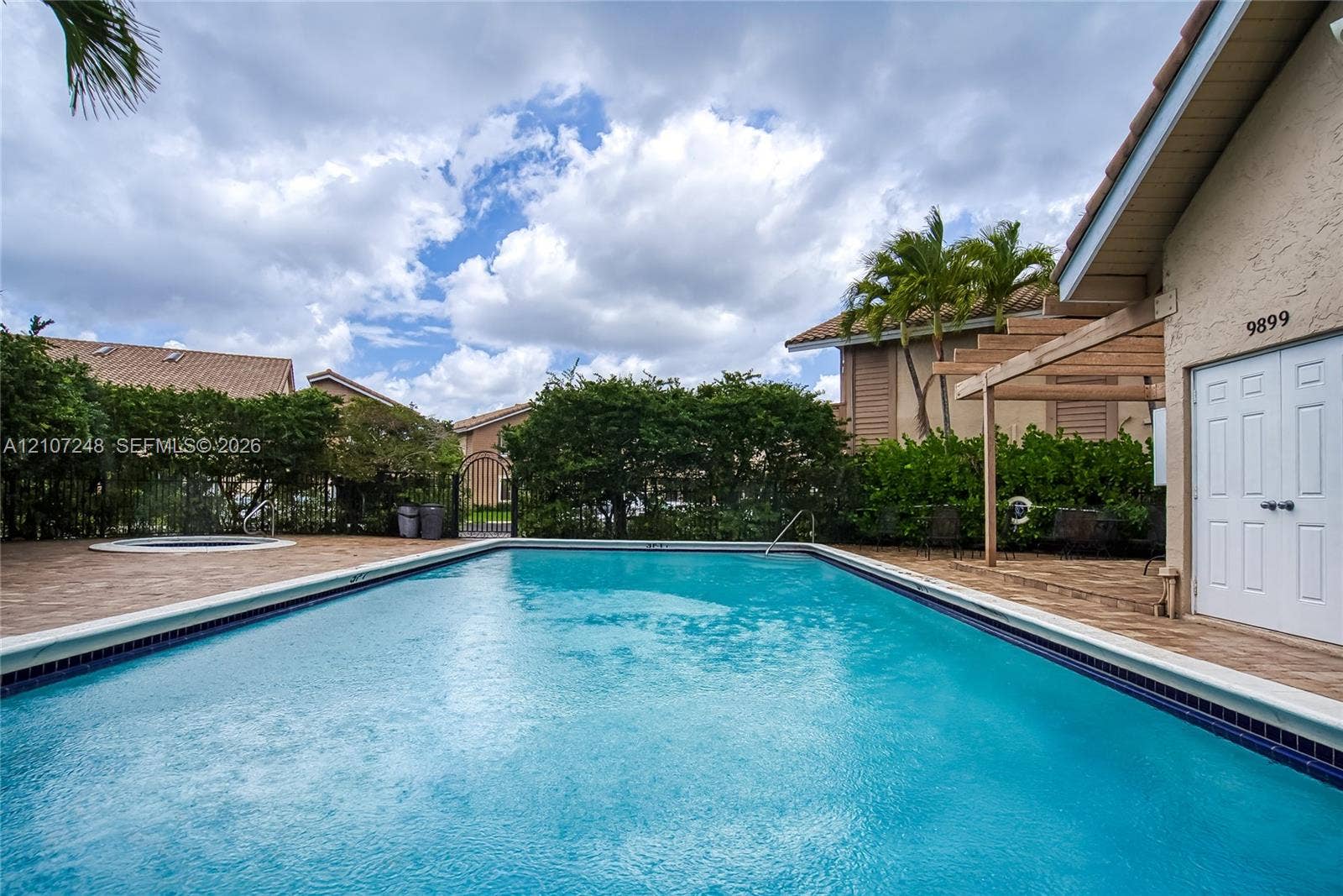 9983 W Atlantic Boulevard, #9983, Coral Springs, Coral Springs, FL 33071 In-ground swimming pool featuring paver decking, an integrated spa, and a wooden pergola structure