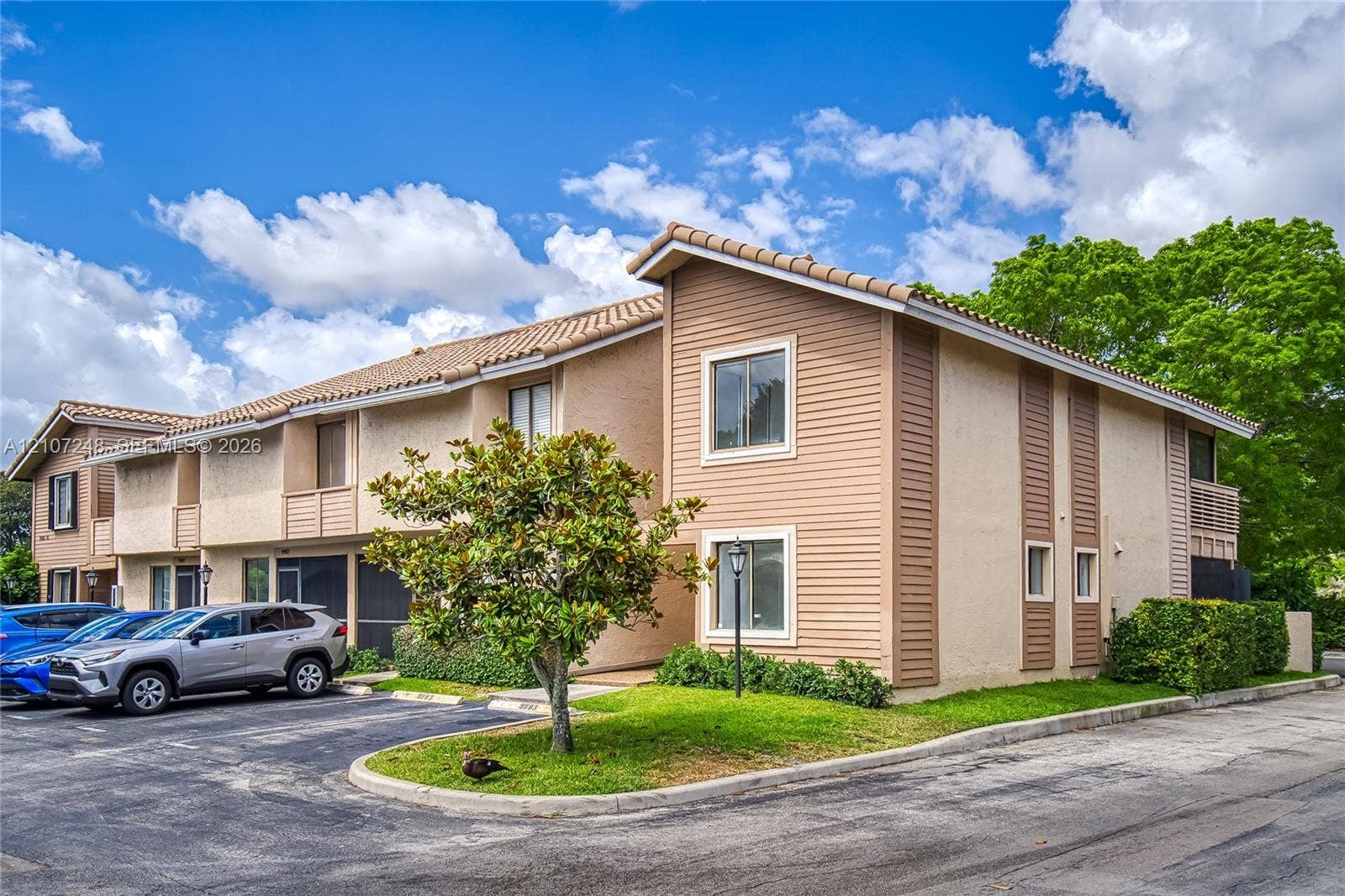9983 W Atlantic Boulevard, #9983, Coral Springs, Coral Springs, FL 33071 Multi-level exterior featuring stucco and horizontal siding, neutral earth-tone palette, tiled roof, and integrated landscaping