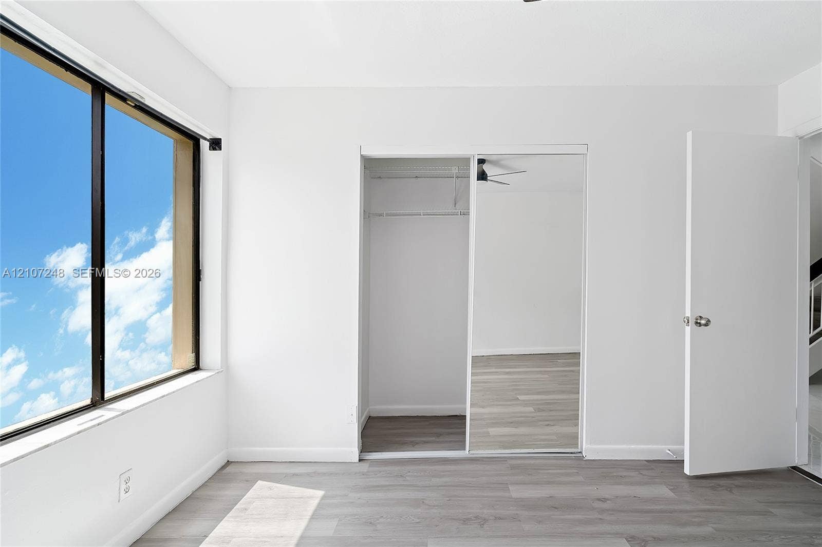 9983 W Atlantic Boulevard, #9983, Coral Springs, Coral Springs, FL 33071 Room with wood-finish flooring, floor-to-ceiling window, and closet featuring mirrored sliding doors