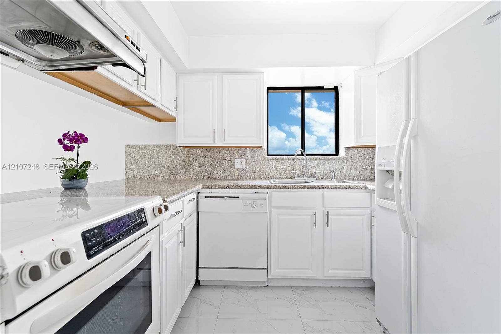9983 W Atlantic Boulevard, #9983, Coral Springs, Coral Springs, FL 33071 Kitchen featuring white shaker-style cabinetry, stone-finish countertops, tile flooring, and integrated white appliances