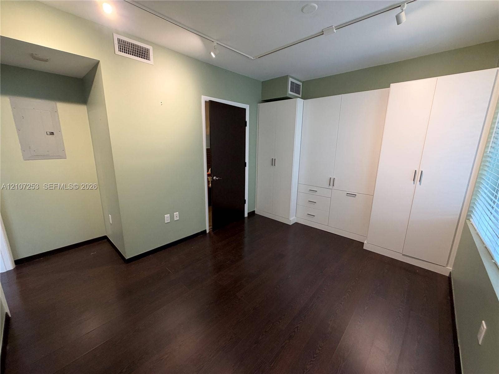 435 21st Street, #316, Miami Beach, Miami Beach, FL 33139 Dark wood-finish flooring complemented by white, built-in floor-to-ceiling cabinetry featuring integrated drawers and brushed metal hardware, high-contrast door finishes, and track lighting