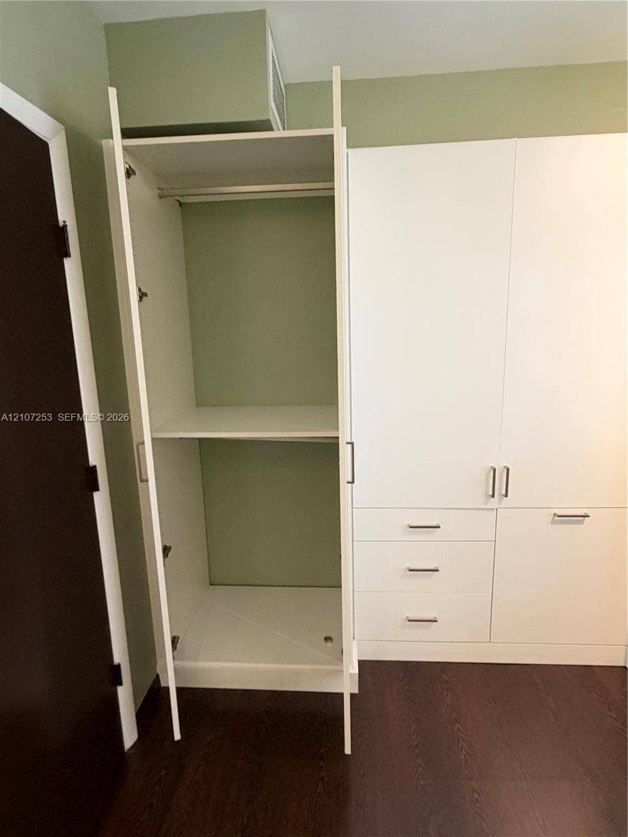435 21st Street, #316, Miami Beach, Miami Beach, FL 33139 Built-in white cabinetry featuring adjustable shelving, a hanging rod, and three lower drawers with metal hardware