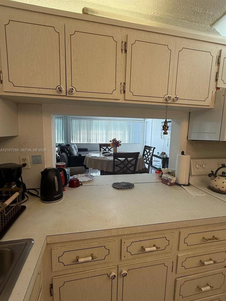 215 SE 3rd Avenue, #102D, Hallandale Beach, FL 33009 Full-wall mirrored accent, decorative multi-tiered light fixture, and ceramic tile flooring