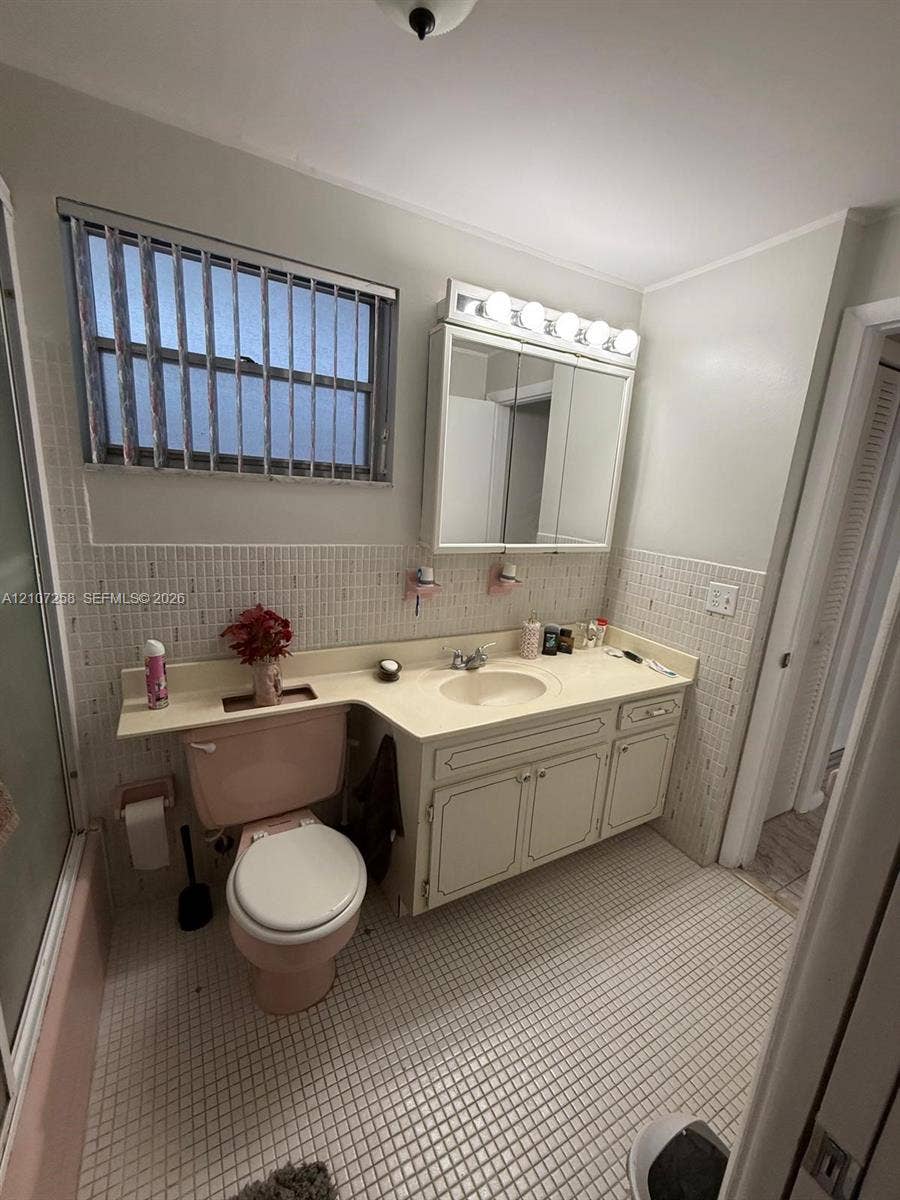 215 SE 3rd Avenue, #102D, Hallandale Beach, FL 33009 Exterior courtyard featuring gravel landscaping, multi-level walkways with white metal railings, and mature palm trees