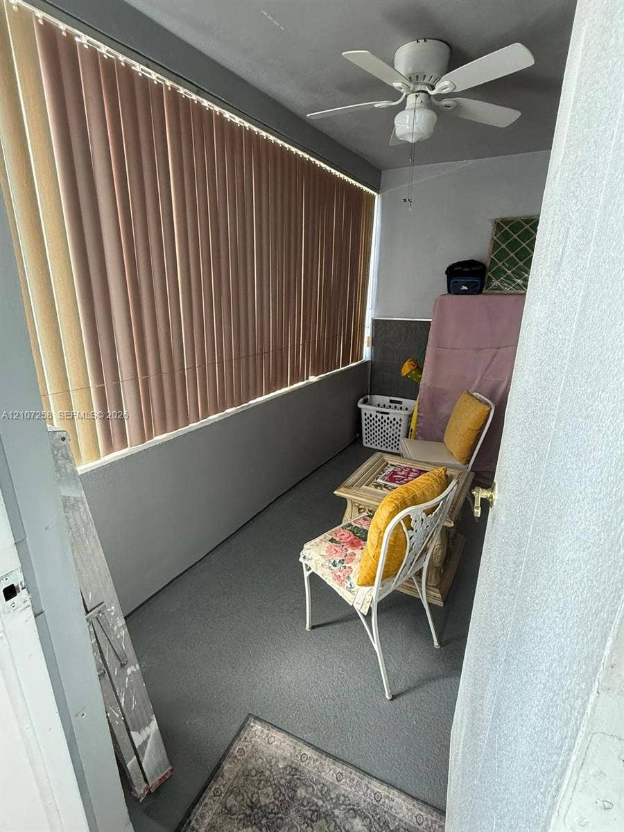215 SE 3rd Avenue, #102D, Hallandale Beach, FL 33009 Tile flooring with neutral veining, ceiling fan with integrated lighting, and sliding glass doors providing access to a balcony