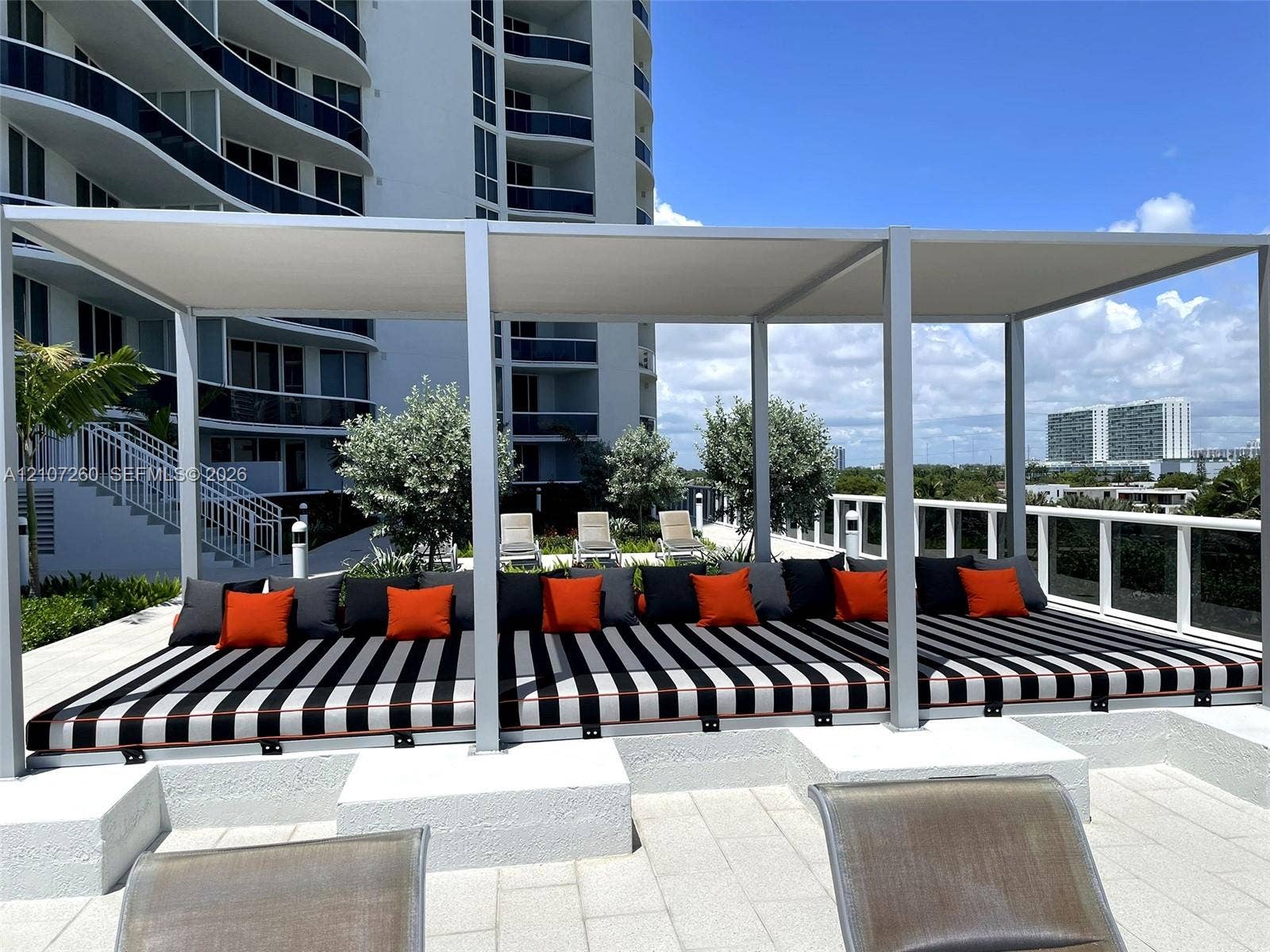16001 Collins Avenue, #1605, Sunny Isles Beach, FL 33160 Outdoor terrace featuring a permanent, rectangular metal-framed pergola, stone-tile flooring, and a raised concrete platform