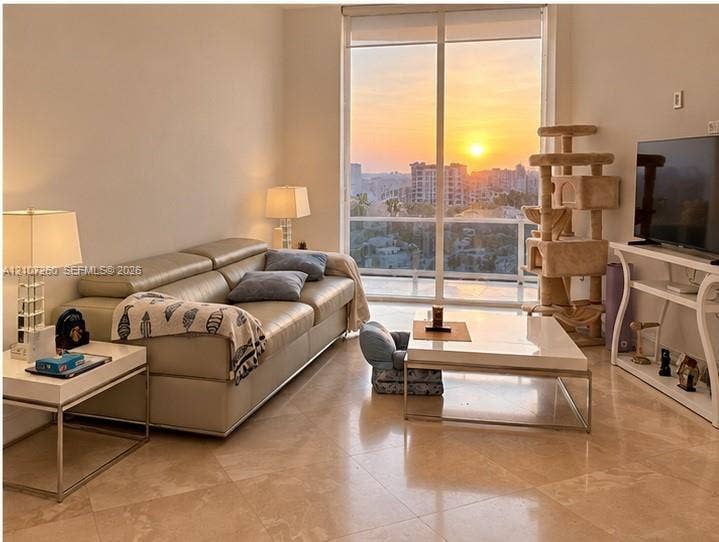 16001 Collins Avenue, #1605, Sunny Isles Beach, FL 33160 Floor-to-ceiling windows with a sunset cityscape backdrop and stone-finish tile flooring