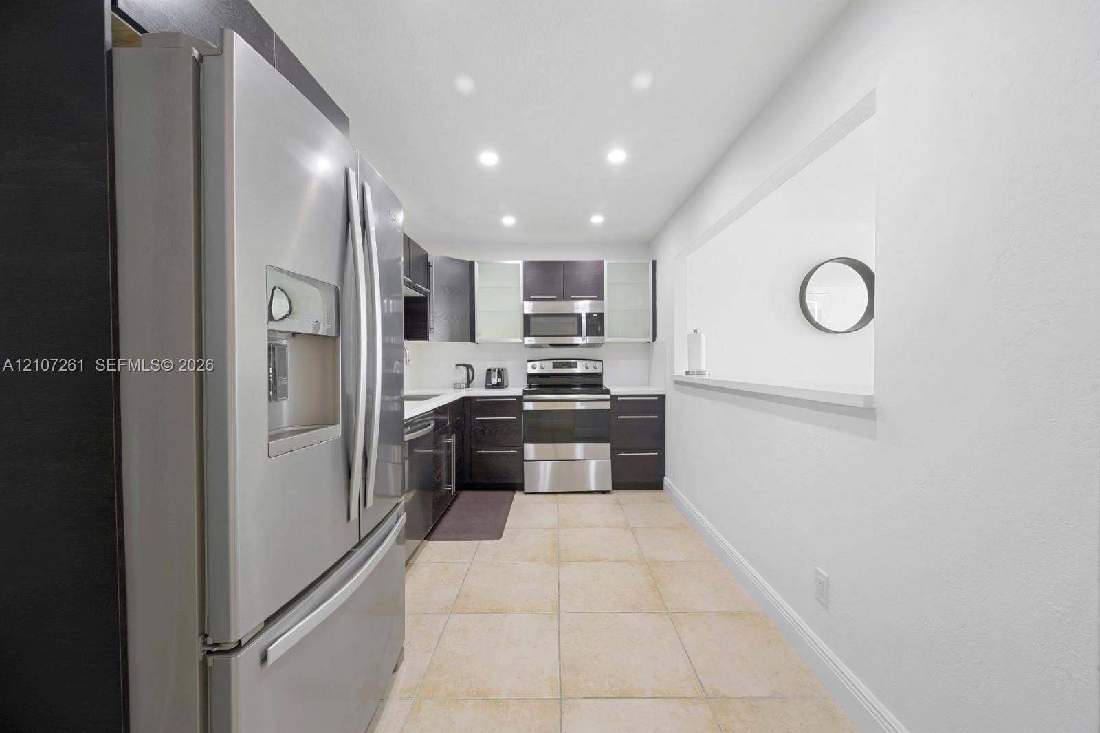 19370 Collins Avenue, #1601, Sunny Isles Beach, Sunny Isles Beach, FL 33160 Kitchen featuring dark cabinetry, stainless steel appliances, recessed ceiling lighting, and tile flooring