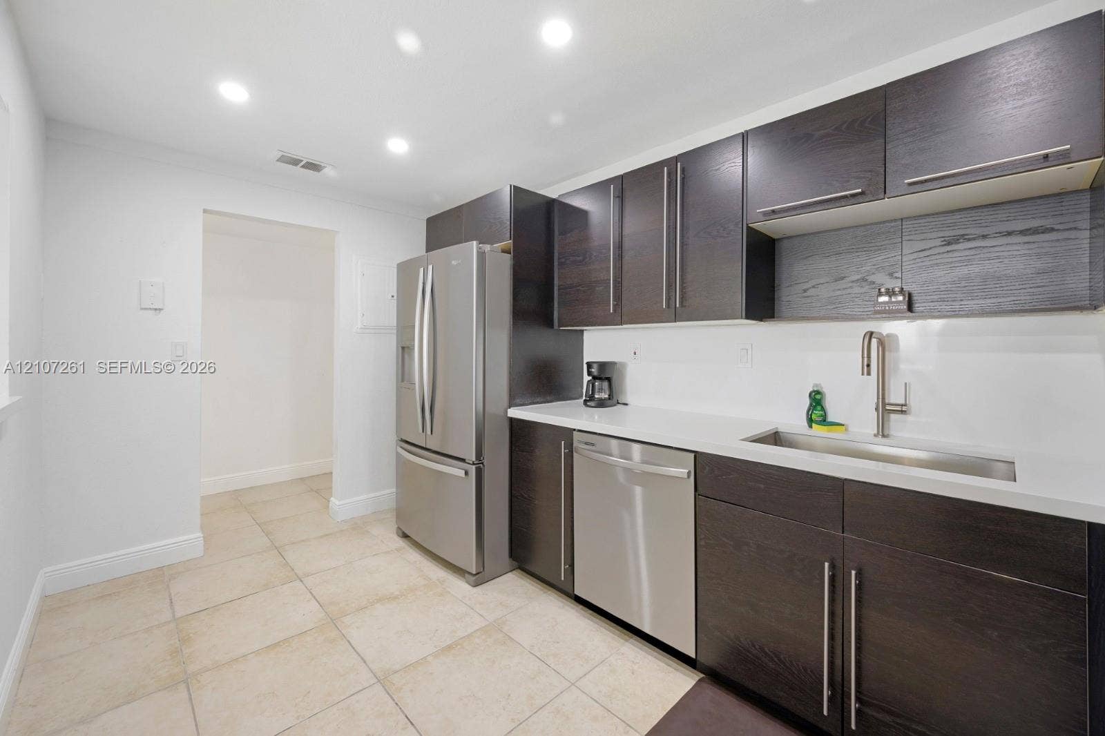 19370 Collins Avenue, #1601, Sunny Isles Beach, Sunny Isles Beach, FL 33160 Kitchen featuring dark wood-finish cabinetry, white solid-surface countertops, recessed ceiling lighting, stainless steel appliances, and tile flooring