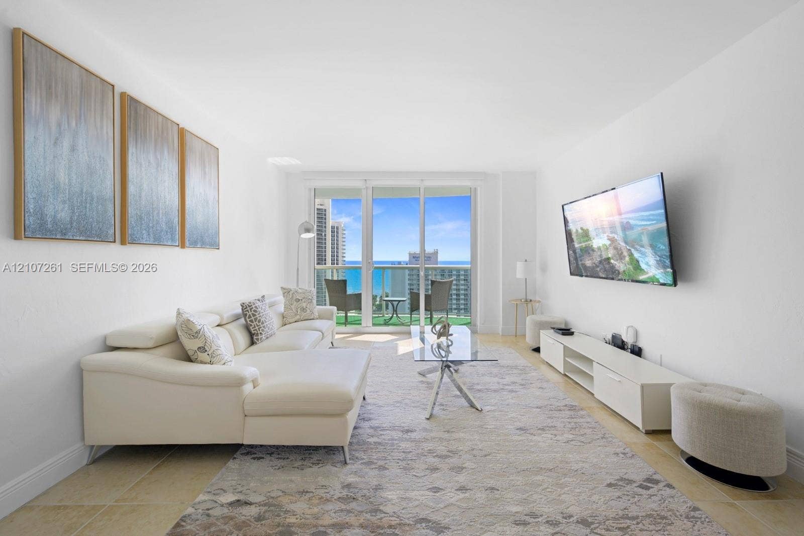 19370 Collins Avenue, #1601, Sunny Isles Beach, Sunny Isles Beach, FL 33160 Living area featuring large-format tile flooring, expansive floor-to-ceiling glass sliding doors, and a private balcony