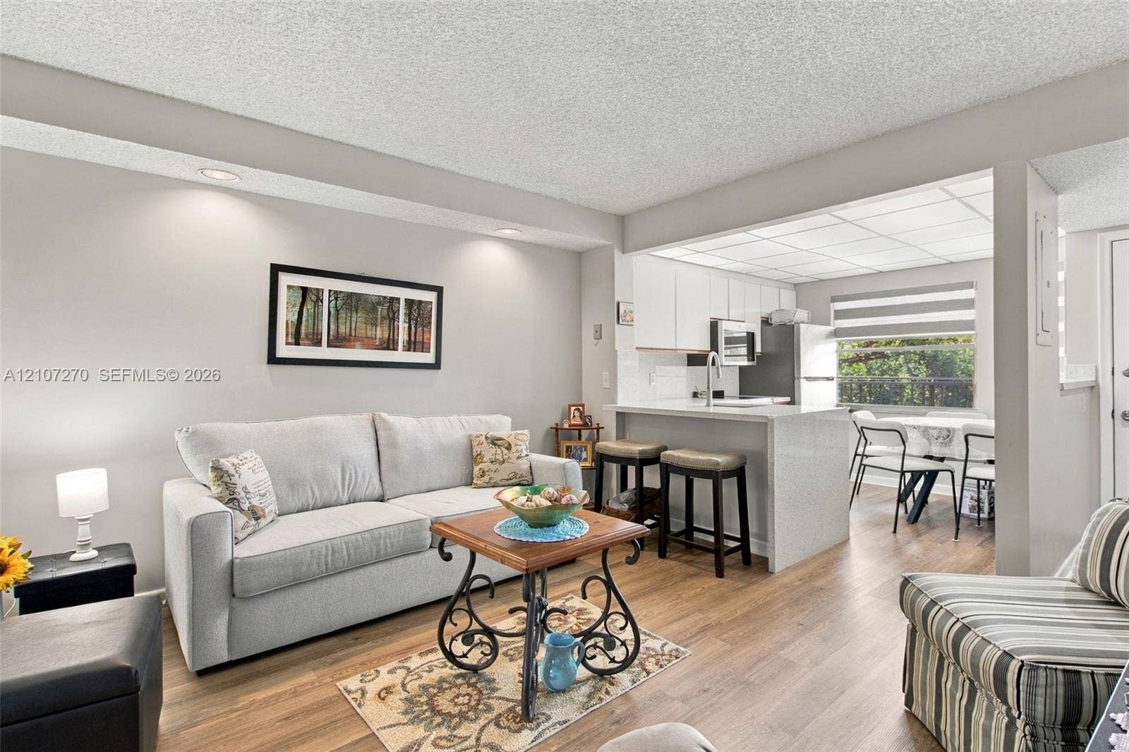 12501 SW 14th Street, #311R, Pembroke Pines, FL 33027 Living area featuring wood-finish flooring, recessed lighting, and a breakfast bar with stone-finish countertops