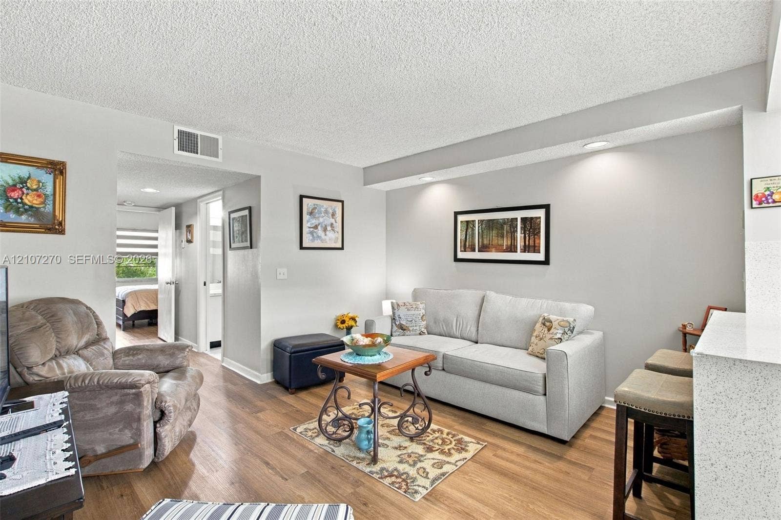 12501 SW 14th Street, #311R, Pembroke Pines, FL 33027 Living area featuring wood-finish flooring, recessed ceiling lighting, and a textured ceiling finish