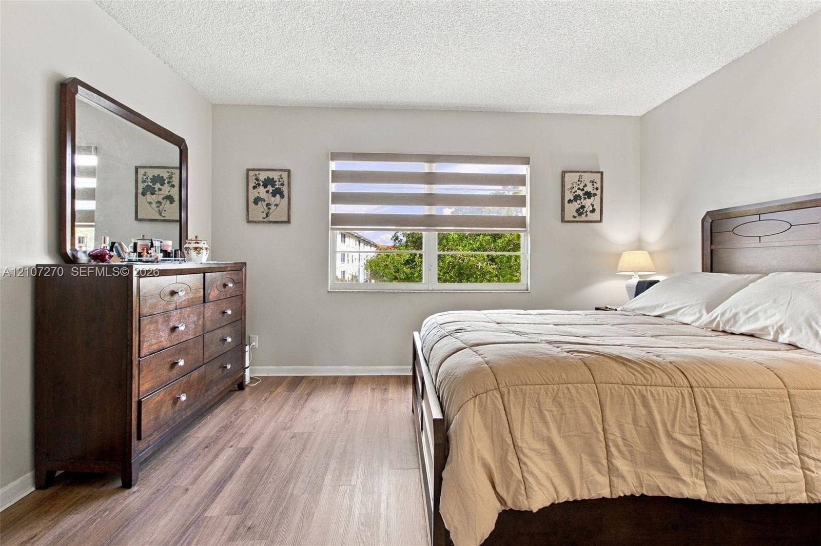 12501 SW 14th Street, #311R, Pembroke Pines, FL 33027 Neutral-toned walls paired with wood-finish flooring and a central window featuring horizontal blinds