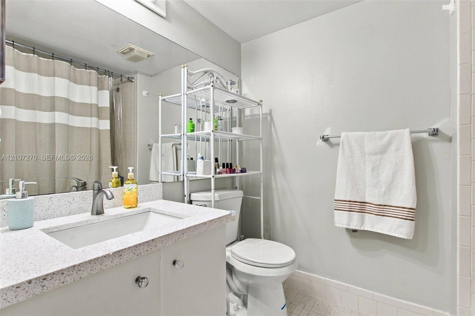 12501 SW 14th Street, #311R, Pembroke Pines, FL 33027 Full-width vanity featuring a stone-composite countertop, integrated sink, matte finish faucet, and expansive wall-mounted mirror