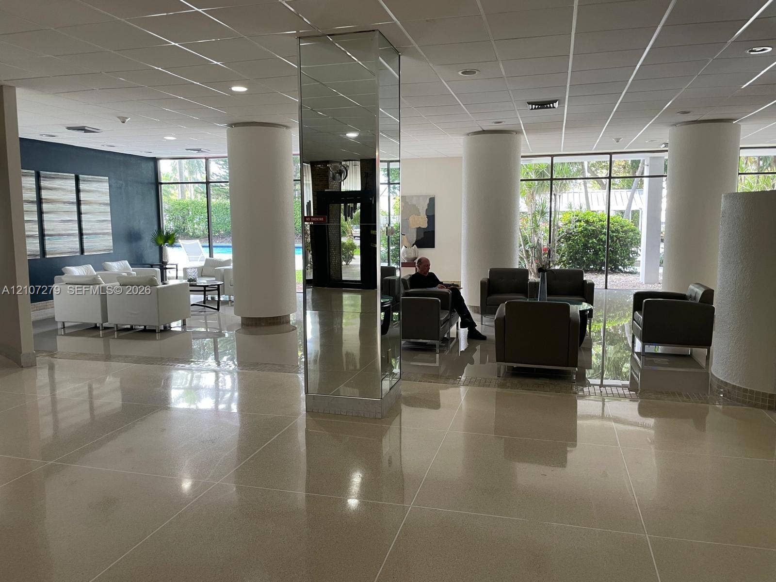 20100 W Country Club Drive, #601, Aventura, FL 33180 Common area featuring polished stone-finish flooring, floor-to-ceiling windows, structural columns, and a central mirrored pillar
