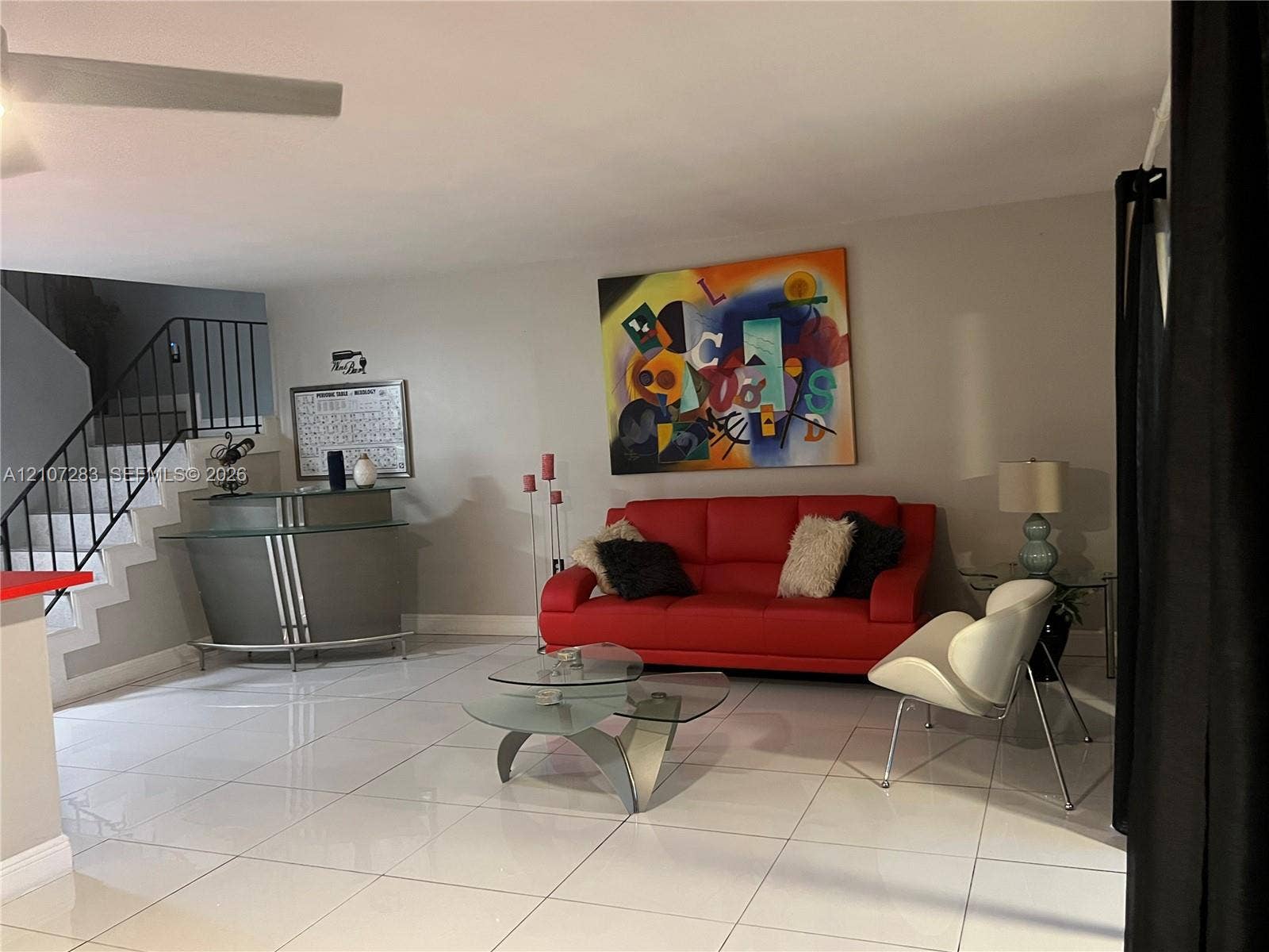 3301 Raleigh Street, #4E, Hollywood, FL 33021 Large-format tile flooring, metal staircase railing, and ceiling-mounted fan