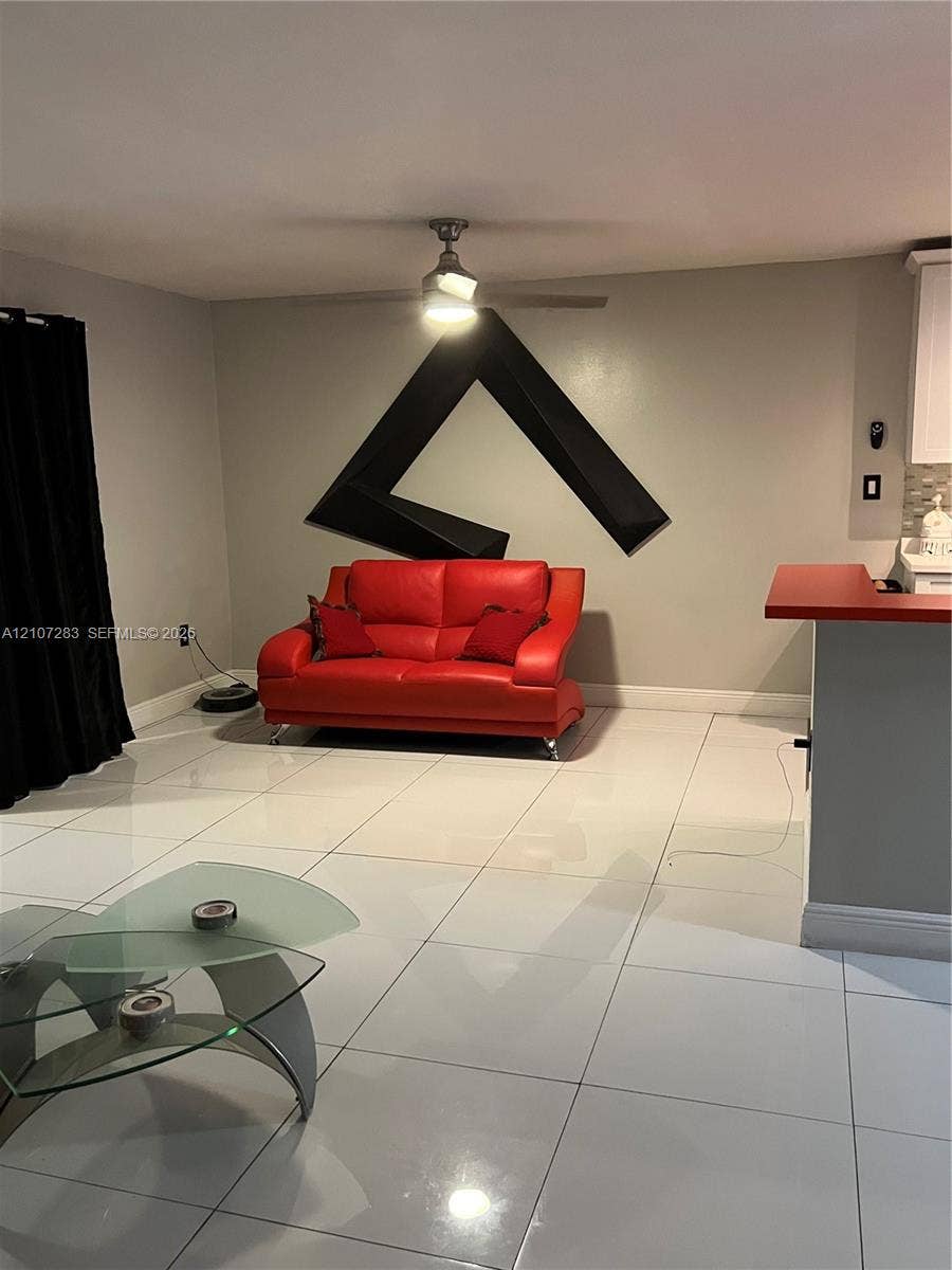 3301 Raleigh Street, #4E, Hollywood, FL 33021 Large-format tile flooring, ceiling fan with integrated lighting, and built-in counter peninsula