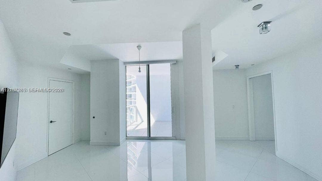 2020 N Bayshore Drive, #2102, Miami, FL 33137 High-gloss floor tiling, ceiling-height glass sliding doors, structural architectural pillar, and recessed ceiling lighting