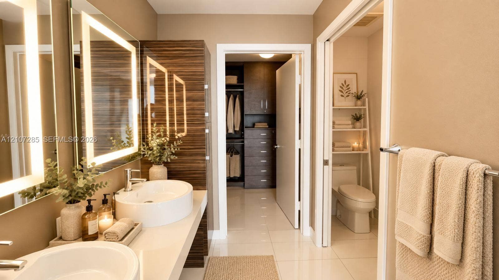 2020 N Bayshore Drive, #2102, Miami, FL 33137 Dual vanity featuring white vessel sinks, quartz countertops, polished metal faucets, and integrated LED-lit mirrors, complemented by floor-to-ceiling wood-finish cabinetry and a walk-in closet with built-in storage ( AI used for interiors )