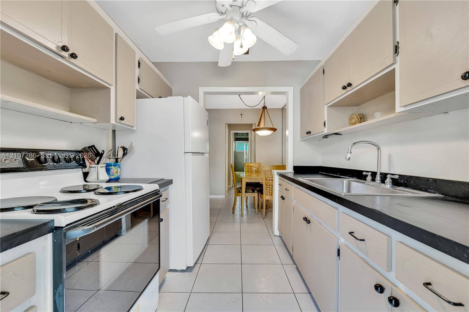2458 Polk Street, #206, Hollywood, FL 33020 Kitchen featuring flat-panel cabinetry, dark solid-surface countertops, tile flooring, and ceiling-mounted lighting
